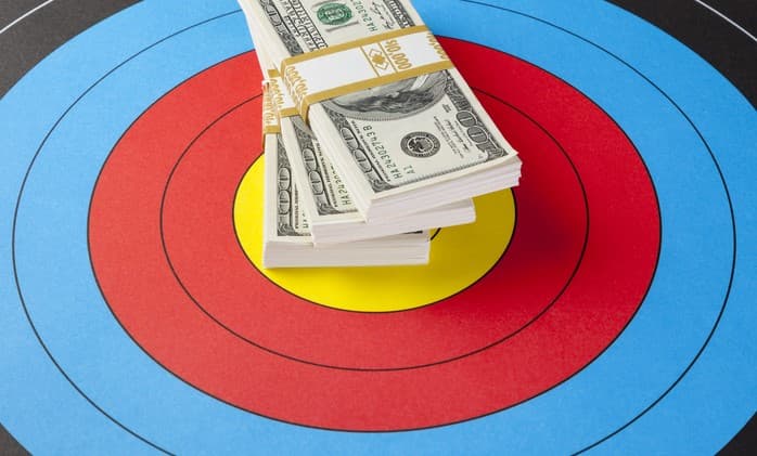 A stack of dollar bills on top of a bullseye