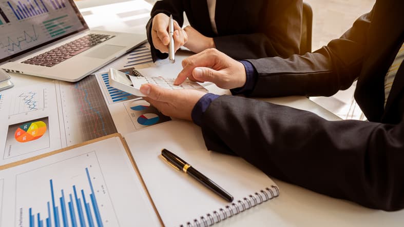 Businessman, accounting, calculating, analyzing, charting and graphing income with a modern laptop computer. And strategy ideas