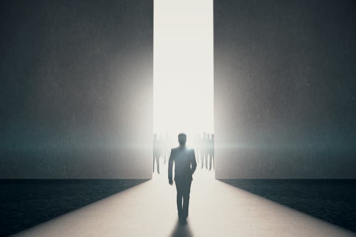 Back view of businessman walking towards abstract opening