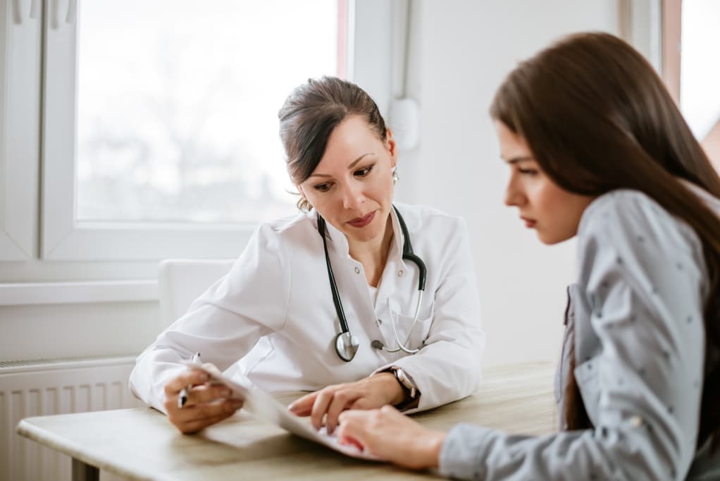 Image of a doctor talking to woman in an office.