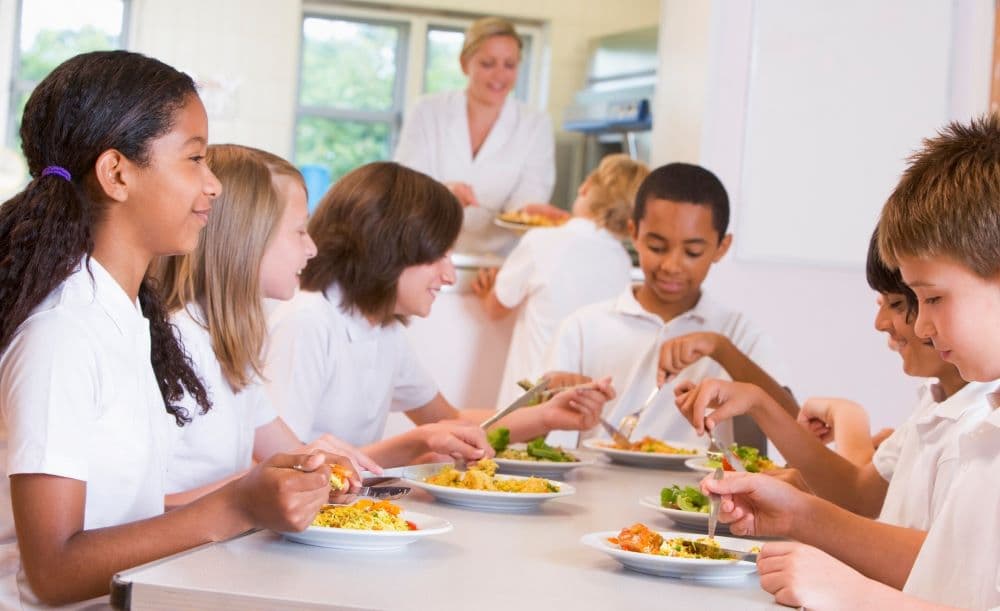 schoolchildren sitting around a cafeteria
