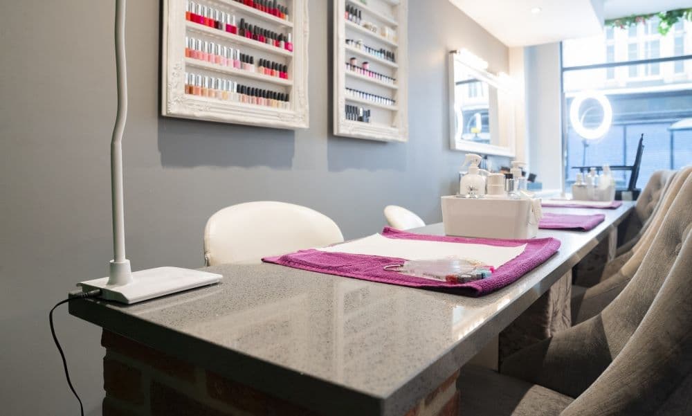 A nail salon with a desk and chairs.