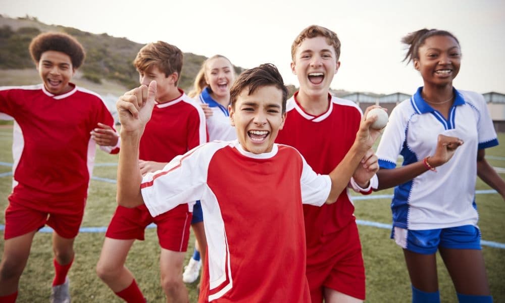 Middle School kids playing soccer together.