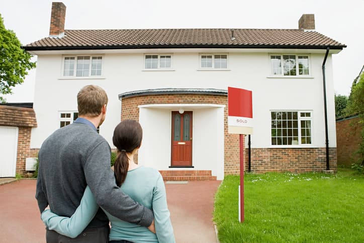Couple outside their new house