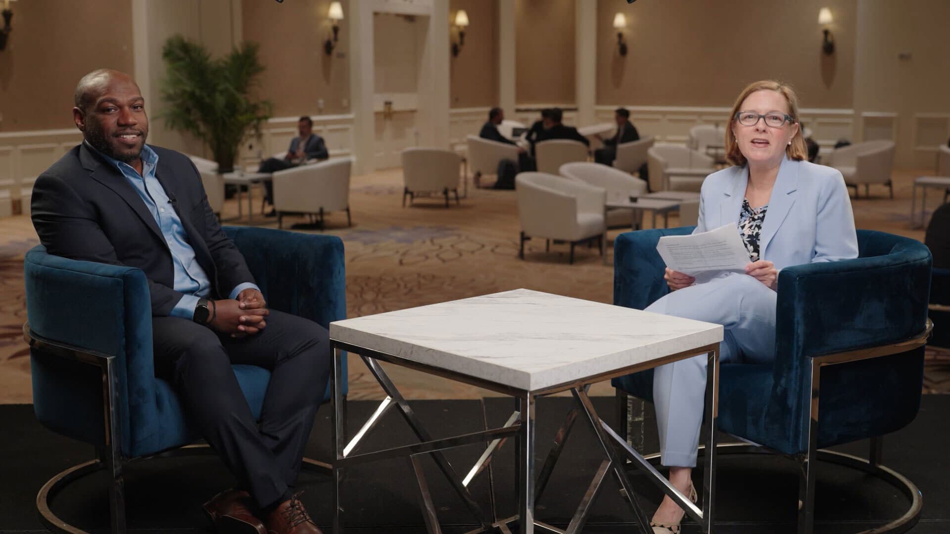 Blackstone's Marcus Felder and PE Hub's Mary Kathleen Flynn in conversation, seated in armchairs
