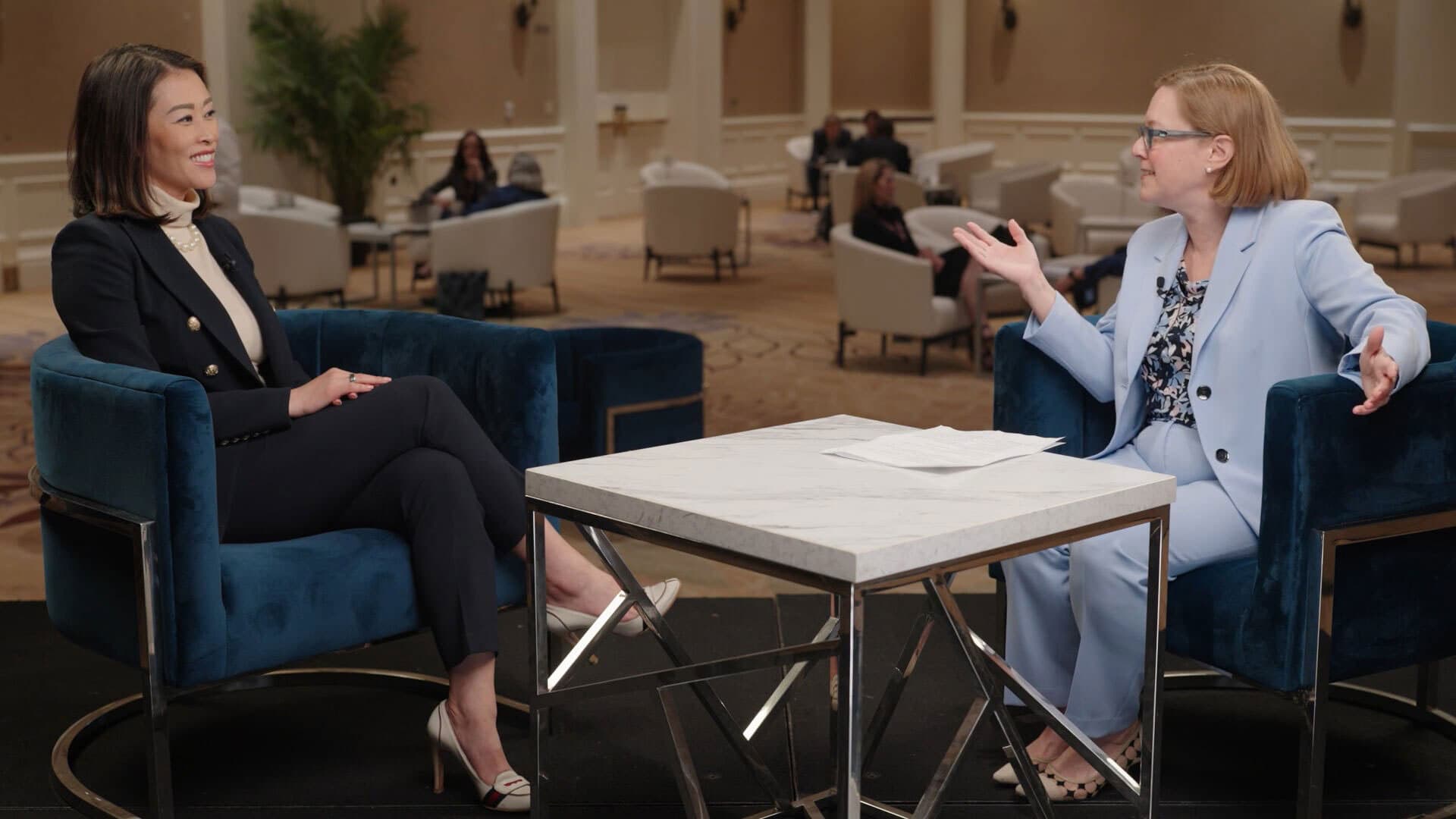 Kinzie Capital's Suzanne Yoon and PE Hub's Mary Kathleen Flynn converse, seated in arm chairs