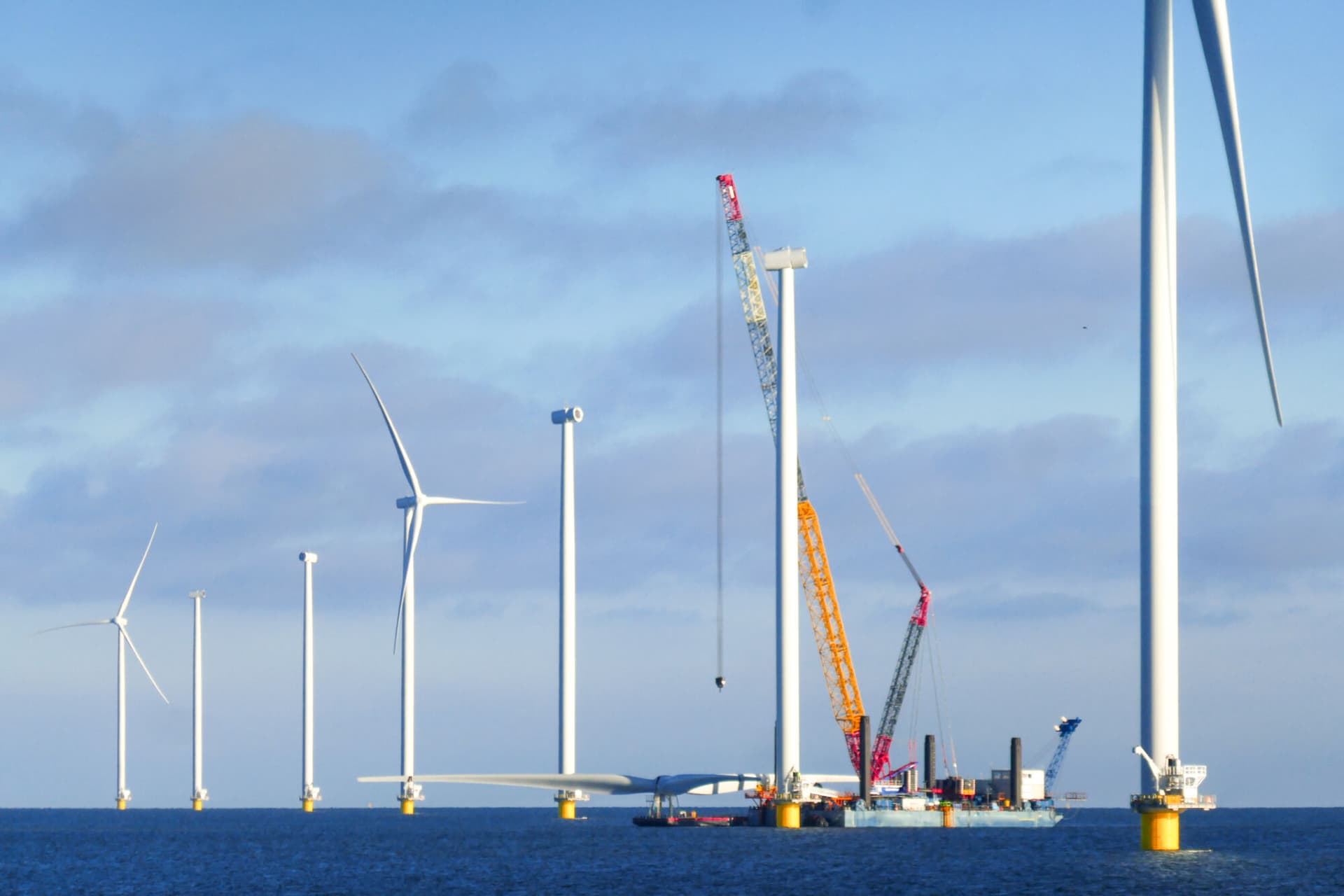 Construction of offshore wind farm - wind turbine in Netherland on the sea (markermeer). Crane ship is preparing for lifting up rotor of the wind turbine.