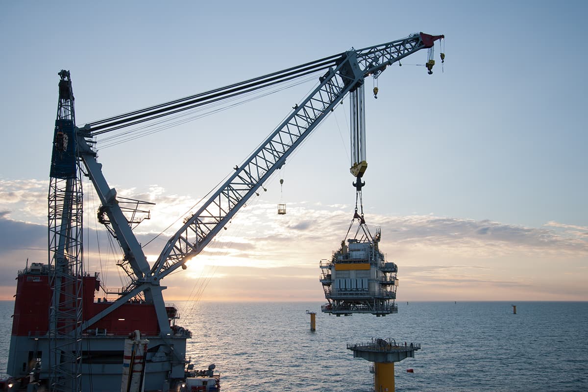 Heavy lift crane vessel installing a topside on a monopile in an offshore wind farm.