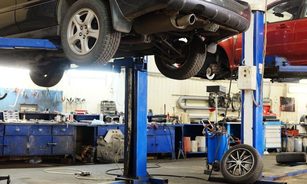 Cars that are being lifted in an auto repair shop for cars.