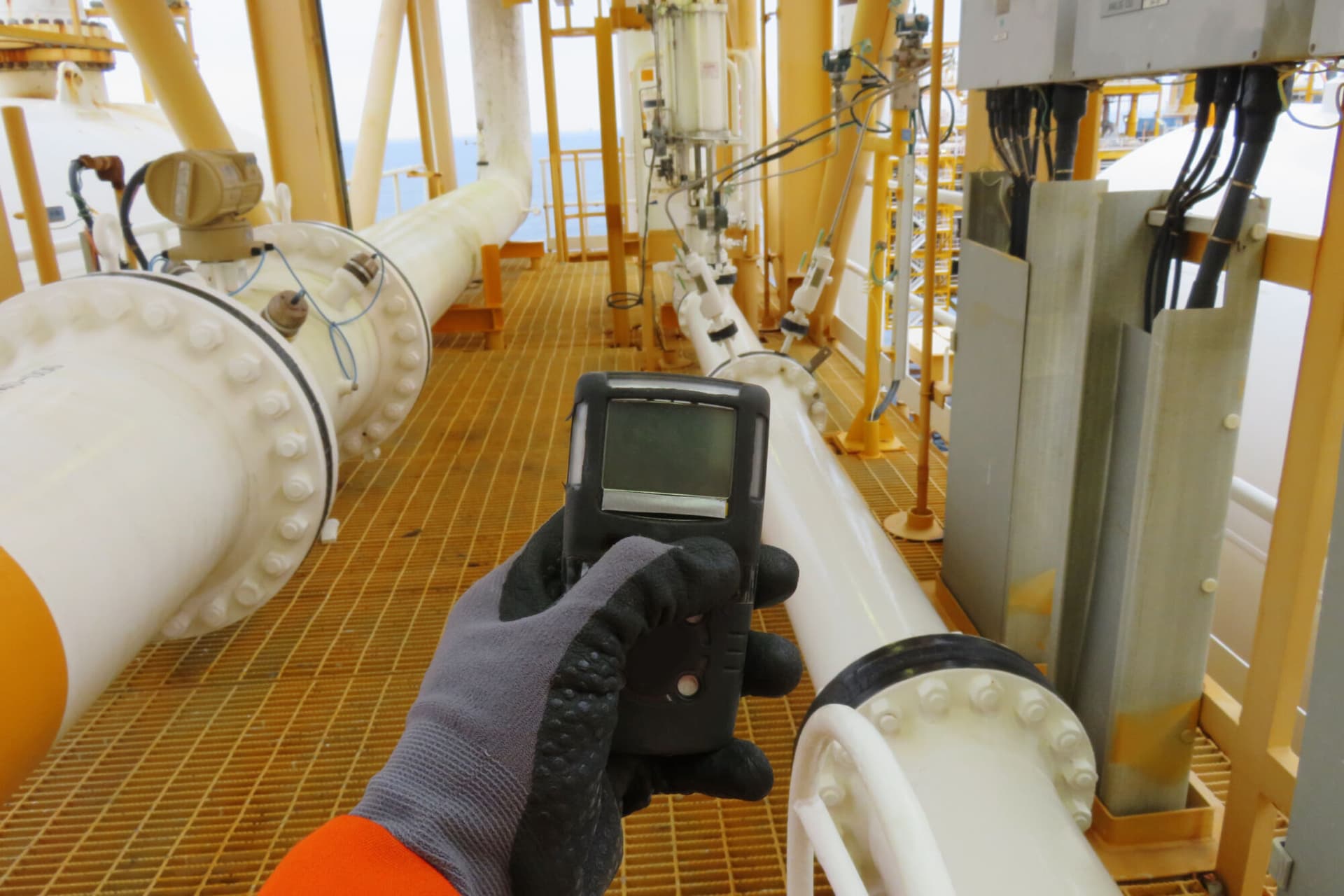 Personal H2S Gas Detector, Check gas leak. Safety concept of safety and security system on offshore oil and gas processing platform, hand hold gas detector.