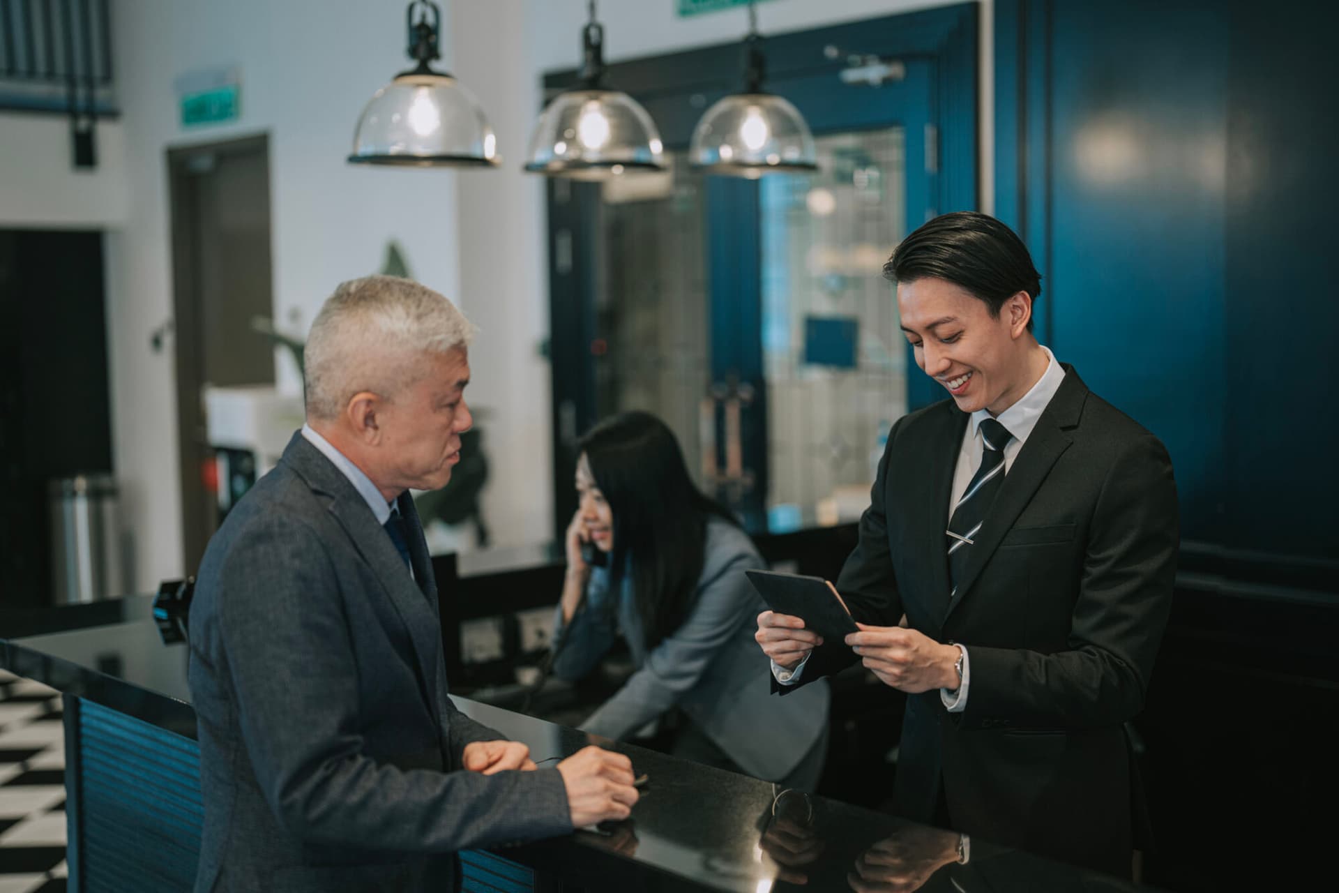 Senior businessman checking in hotel showing passport to receptionist