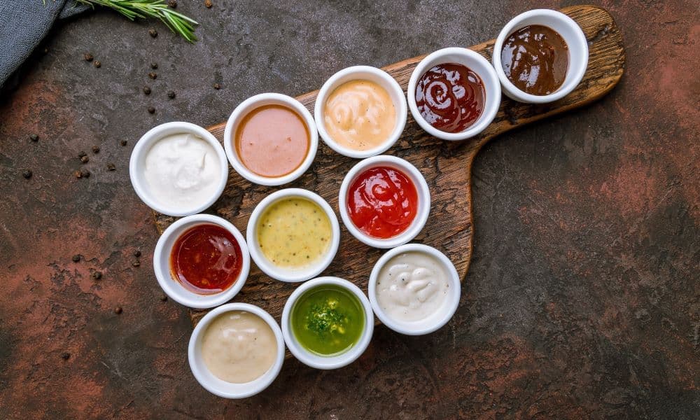 Picture of dipping sauces and condiments on a rustic background.