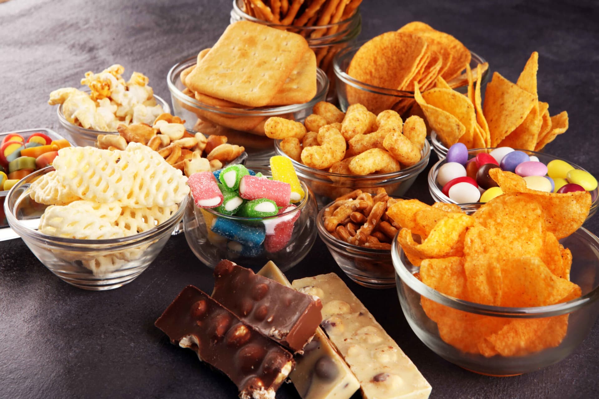 Salty snacks. Pretzels, chips, crackers in glass bowls.