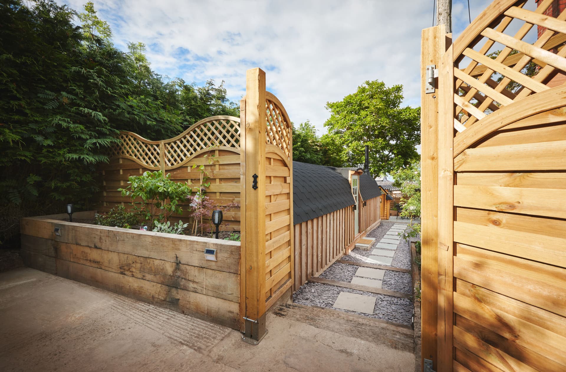 Property, home and exterior of backyard, entrance and door by architecture with walkway. Residential real estate, house or garden fence, trees or path by building patio outdoor on landscape in summer.