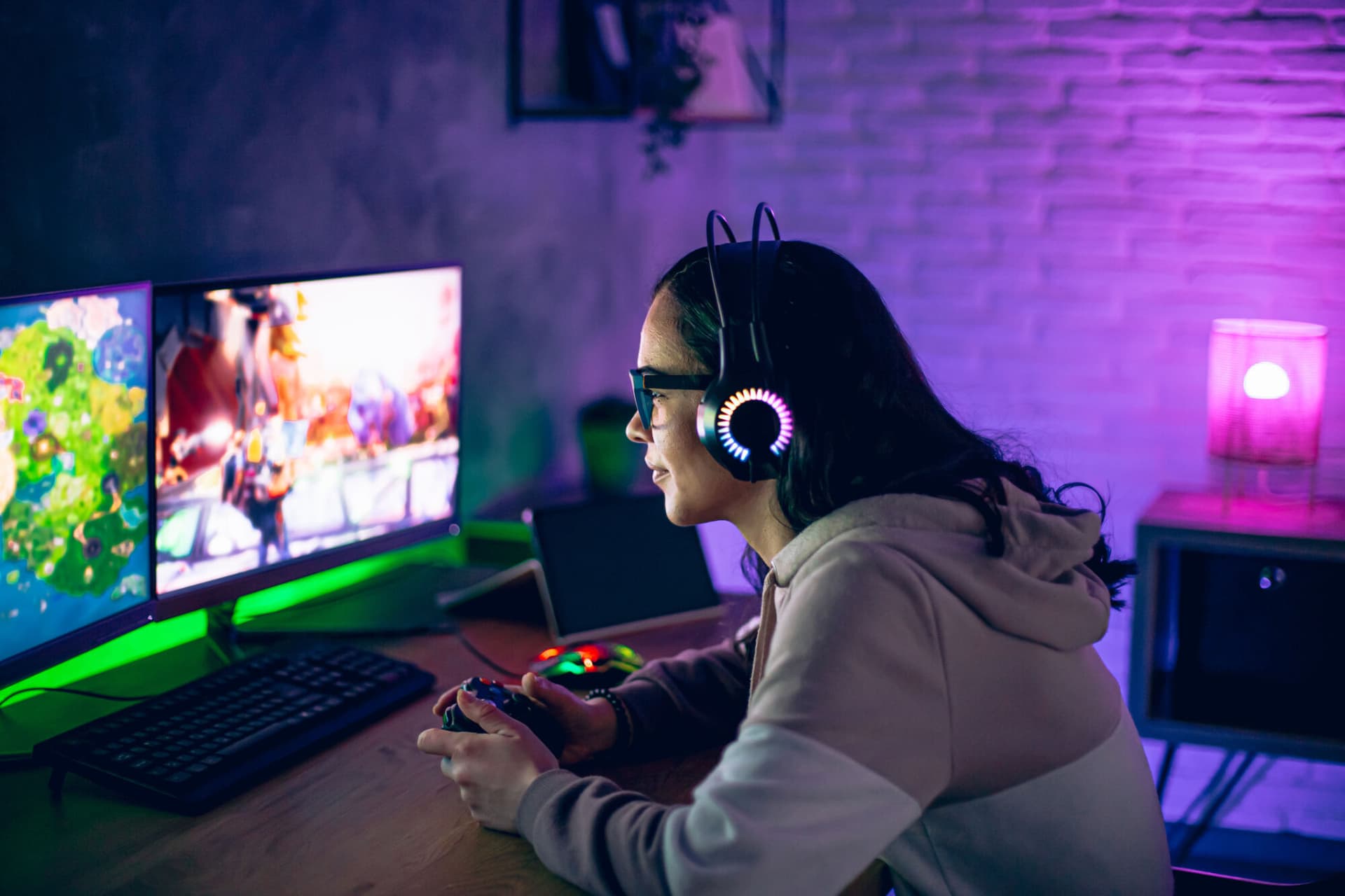 Woman gamer plays online video game on joystick at home at night