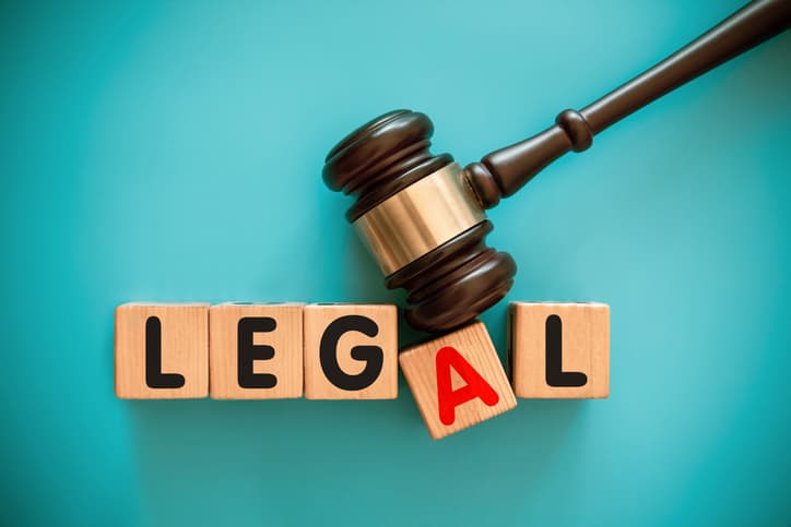 Gavel and toy block with "LEGAL" on blue background.