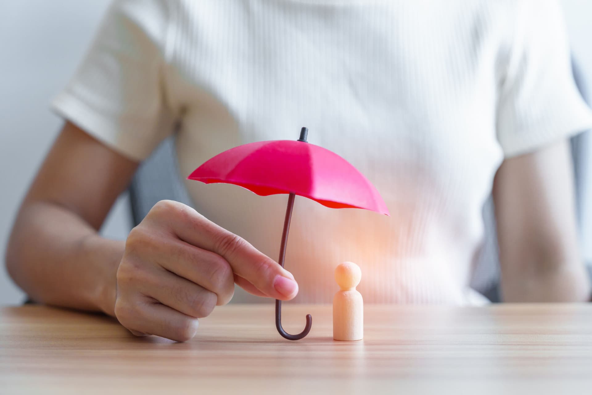 Health insurance concept with red umbrella over a figurine