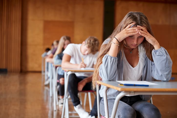 Anxious Teenage Student Sitting Examination In School Hall