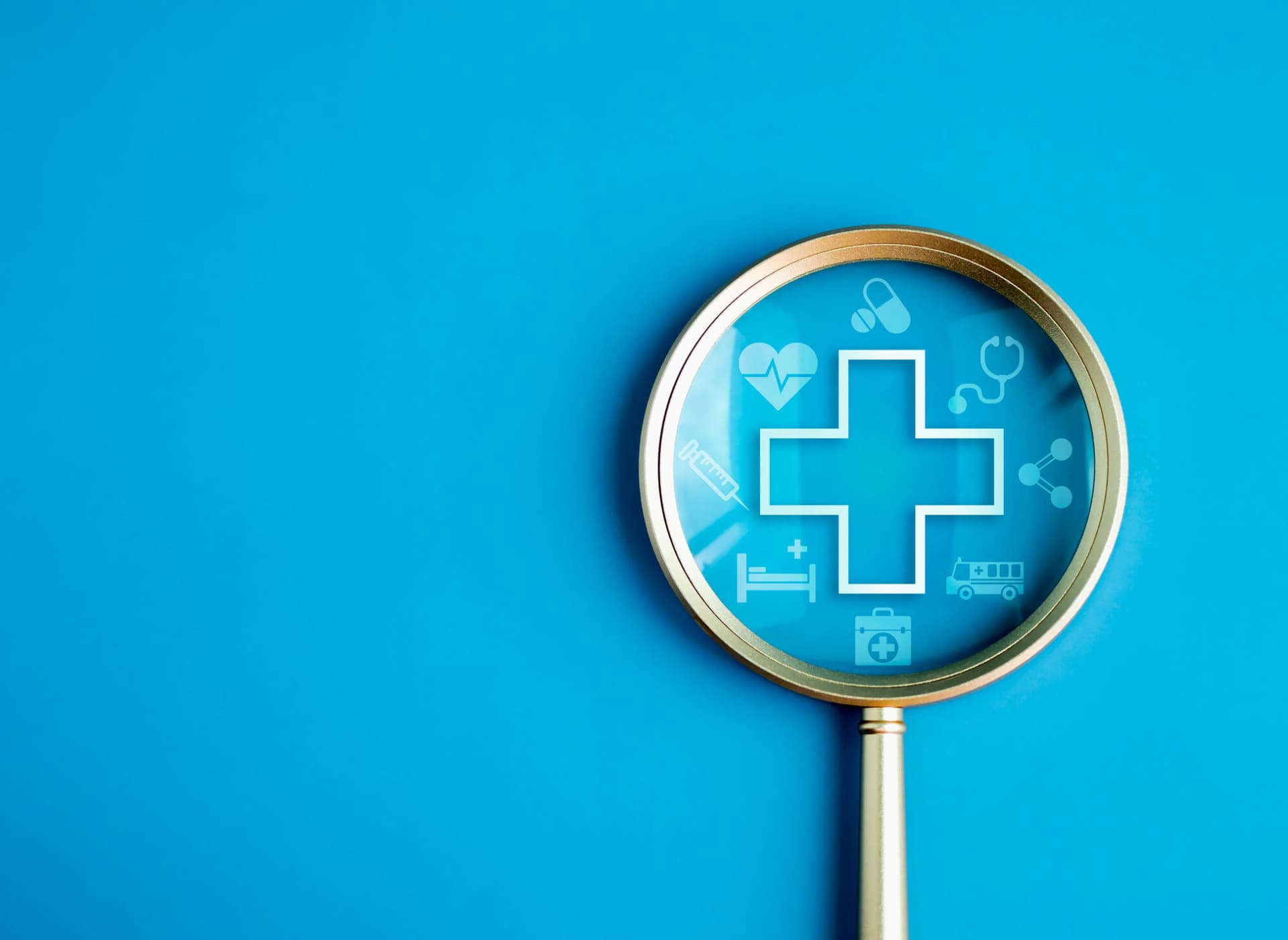 Image of a magnifying glass with medical symbols inside.