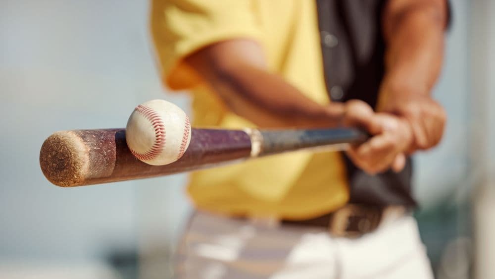 Baseball player hitting a baseball with a bat.