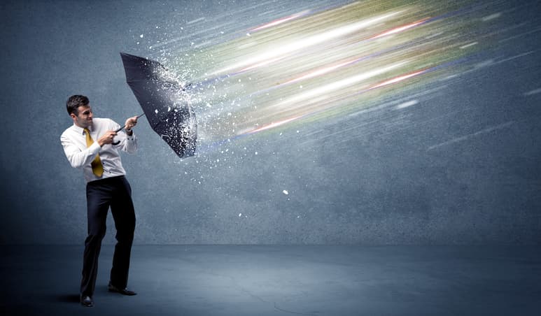 Business man defending light beams with umbrella