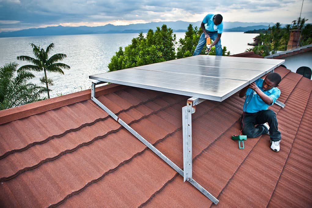 Men working on a solar panel on a roof