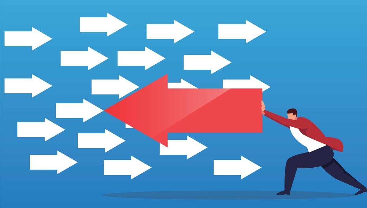 Businessman pushing arrow in opposite direction