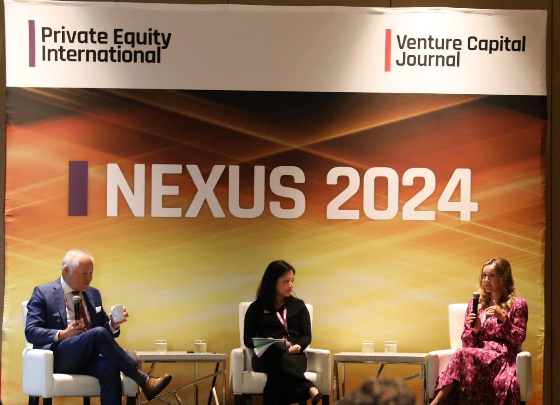 Panellists speaking onstage at PEI Group's NEXUS 2024 summit