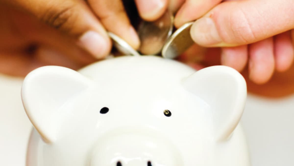 Putting coins into a piggy bank