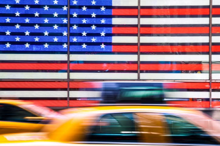 A New York cab driving past the US flag