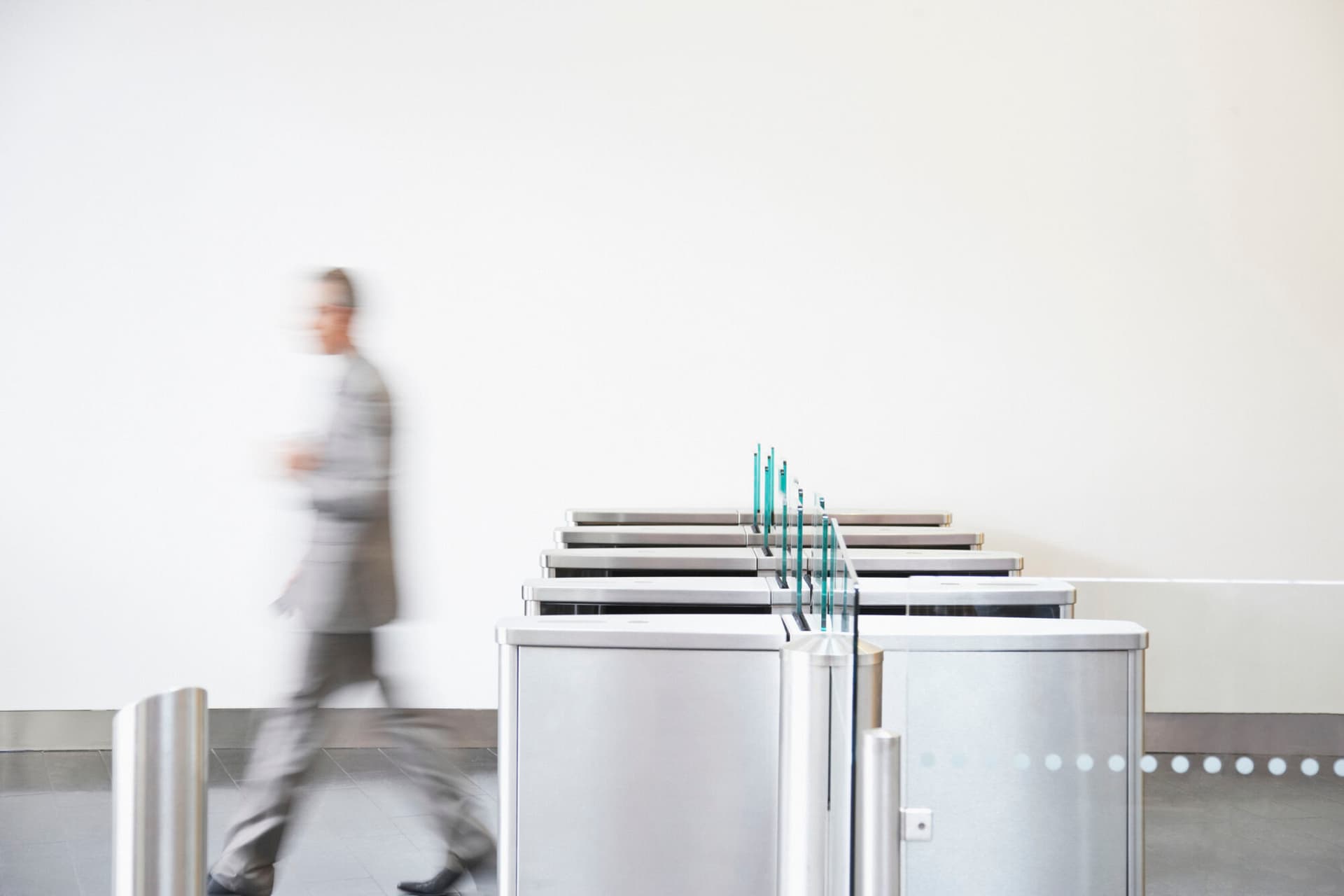 A businessman exiting a company through its security turnstiles