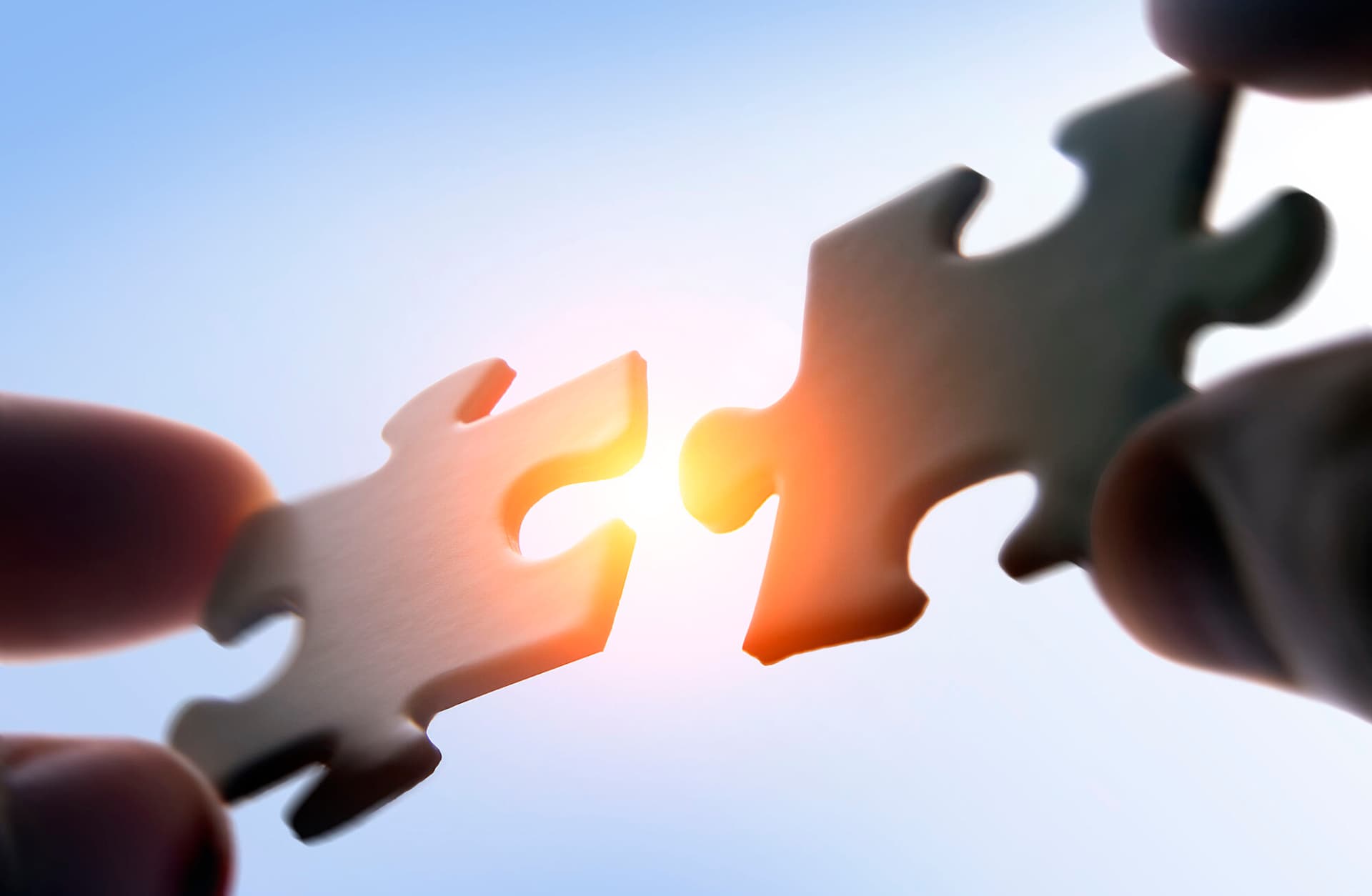 two puzzle pieces are close to connecting - illustrating a merger