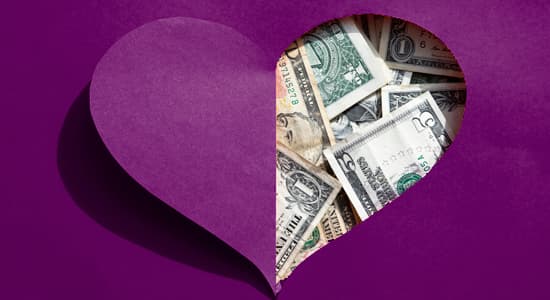 A love-heart shaped hole in a piece of people reveals US dollars underneath