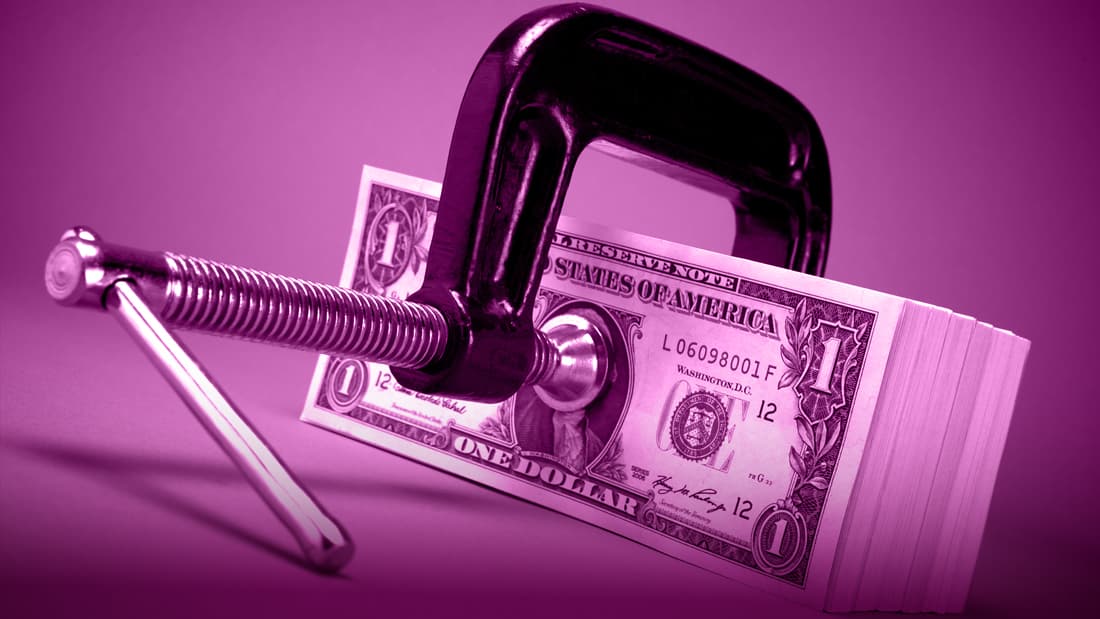 A clamp grips onto a stack of dollar bills