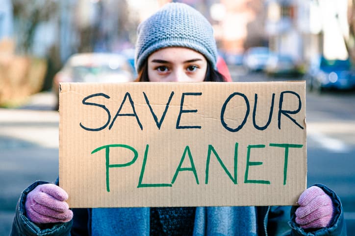 Young activist holding sign protesting against climate change